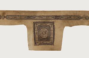 Dit fragment van een Egyp􀆟sche tuniek dateert uit 500 tot 800 na Chr. Het is een deel van de schouder, geweven van linnen met versieringen in purperkleurige wol